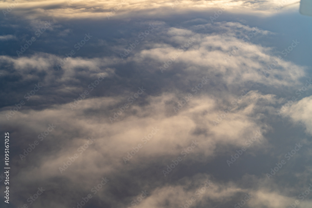 View of fluffy clouds against a blue sky captured during a flight at dusk highlighting the serene beauty of nature from above View of fluffy clouds against a blue sky captured during a flight at dusk highlighting the serene beauty of nature from above