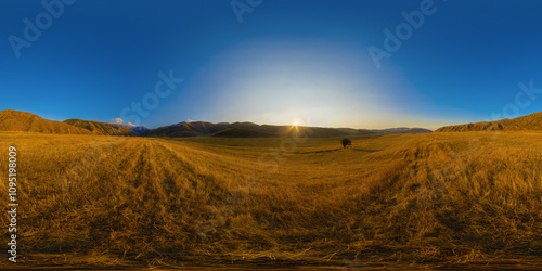 Full Spherical panorama of straw moved agricultural field surrounded with foothills at autumn sunset with blue sky in equirectangular projection