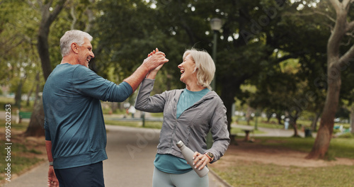 High five, senior couple and park for fitness goals, happy for wellness win with workout and bottle for water. Success, support and exercise, man and woman for retirement bonding outdoor with drink photo