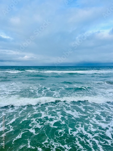 Cloudy seascape, seashore waves, natural sea horizon, cloudy sky