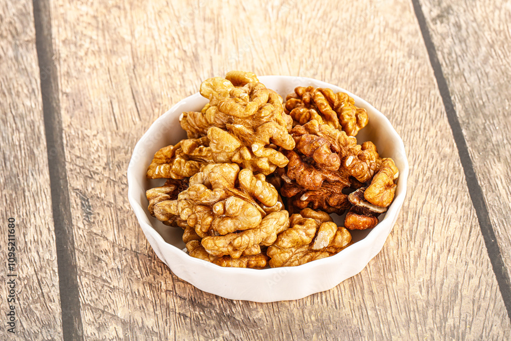 Cracked unshelled walnut in the bowl Cracked unshelled walnut in the bowl