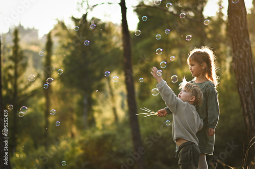 Wallpaper Mural a boy and a girl are walking in the forest and blowing soap bubbles Torontodigital.ca