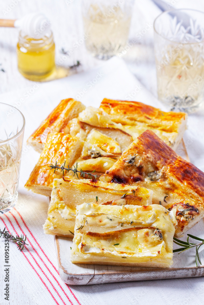 Puff pastry pie with cheese, pears, nuts and honey, served with champagne.
