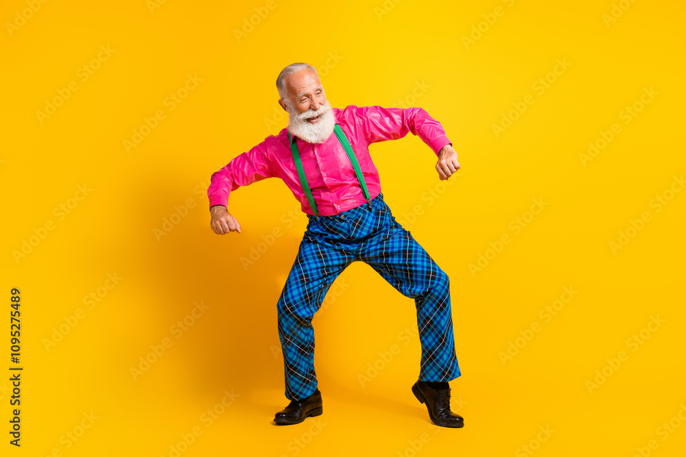 Full body photo of retired man dancing good mood dressed pink shirt vintage plaid pants fancy clothes isolated on yellow color background Full body photo of retired man dancing good mood dressed pink shirt vintage plaid pants fancy clothes isolated on yellow color background
