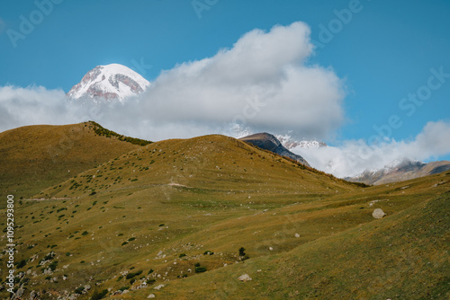 View on Mount Kazbek playing hide and seek with the clouds near Gergeti Trinity church, in Kazbegi, Georgia photo