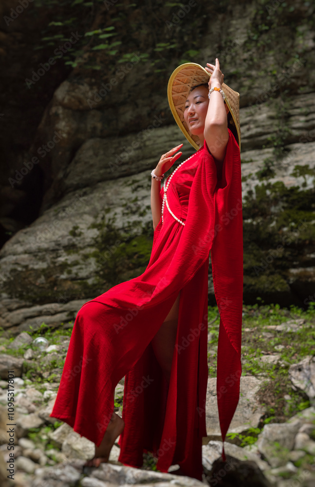 Asian girl in a beautiful red kimono and a Vietnamese triangular hat poses sexually in the bosom of nature in a rocky canyon Asian girl in a beautiful red kimono and a Vietnamese triangular hat poses sexually in the bosom of nature in a rocky canyon