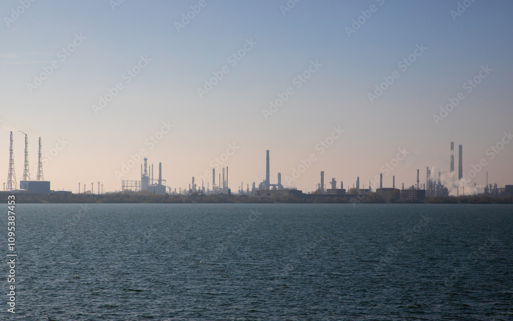 Naklejka premium Landscape with the silhouette of a refinery seen from a distance