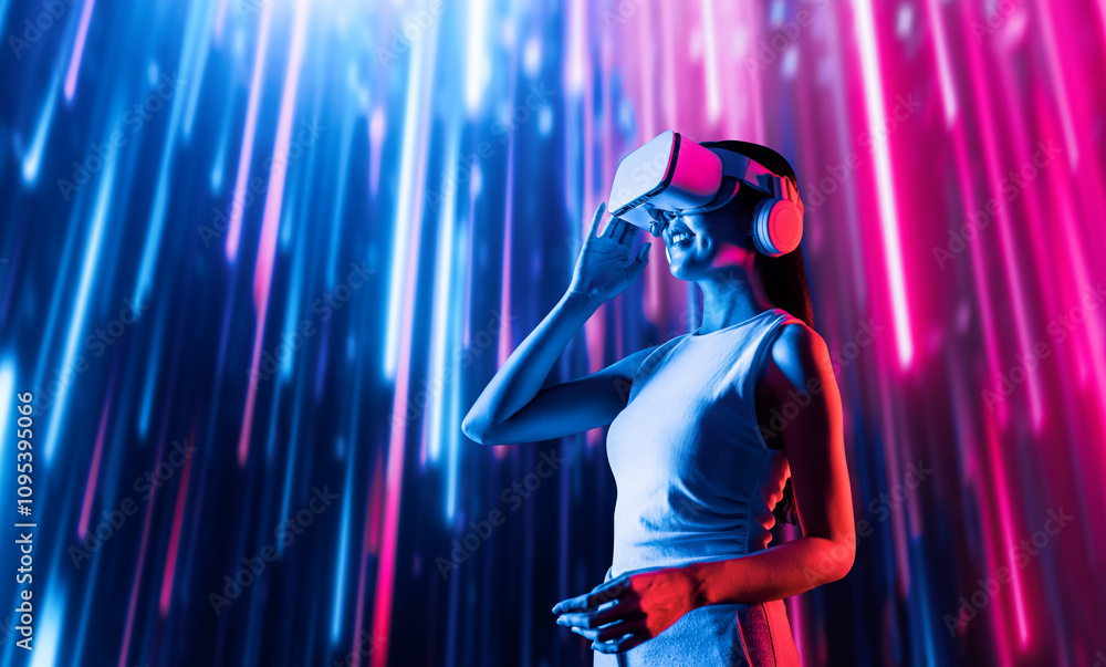 Smart female standing surrounded by neon light wearing VR headset connecting metaverse, future cyberspace community technology. Elegant woman looking faraway and smiling satisfactorily. Hallucination. Smart female standing surrounded by neon light wearing VR headset connecting metaverse, future cyberspace community technology. Elegant woman looking faraway and smiling satisfactorily. Hallucination.