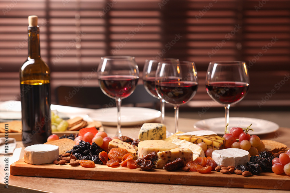Glasses of red wine and different snacks on wooden table, selective focus Glasses of red wine and different snacks on wooden table, selective focus