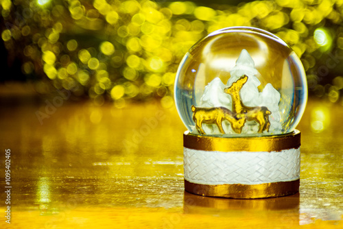 christmas decoration snow ball glass sphere globe with golden christmas ball blur background