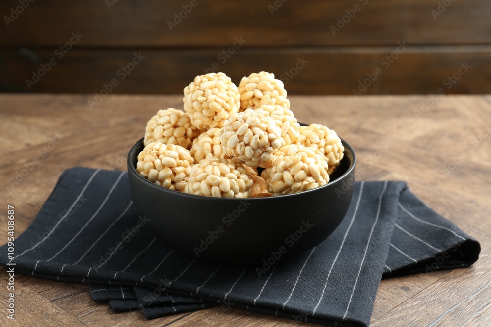 Tasty puffed rice balls in bowl on wooden table Tasty puffed rice balls in bowl on wooden table