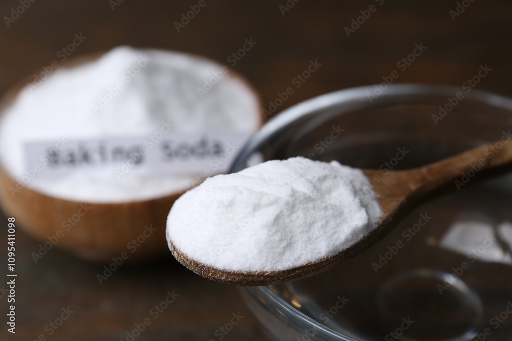 Glass of water and baking soda on wooden table, closeup Glass of water and baking soda on wooden table, closeup