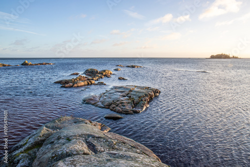 Shore of a lake at sunrise. Landscape shot in the Narur in the morning. Forests lake and water at the beginning of winter or in autumn. Sweden, Scandinavia photo