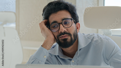 Slika na platnu Sleepy tired Arabian Indian man businessman lazy worker employee manager working