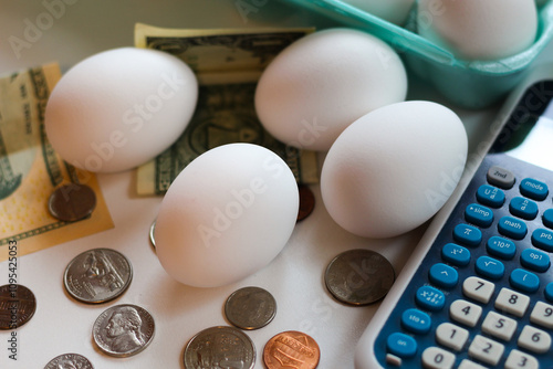 close-up of eggs on the table against money and calculator backdrop for cost of groceries market financial consumer budget theme photo