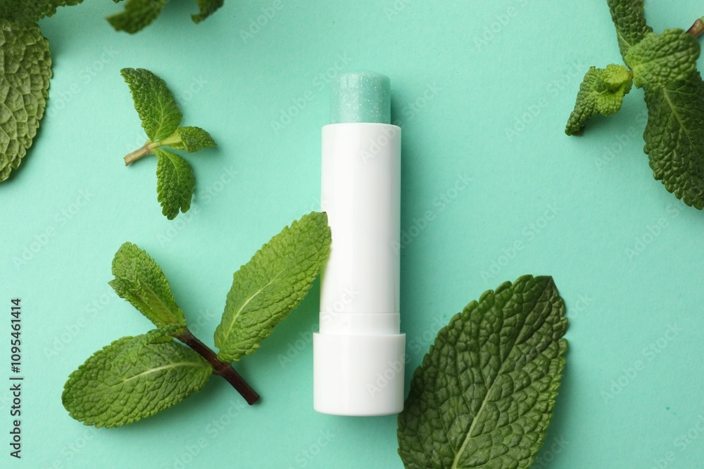 Natural lip balm and mint leaves on turquoise background, flat lay Natural lip balm and mint leaves on turquoise background, flat lay
