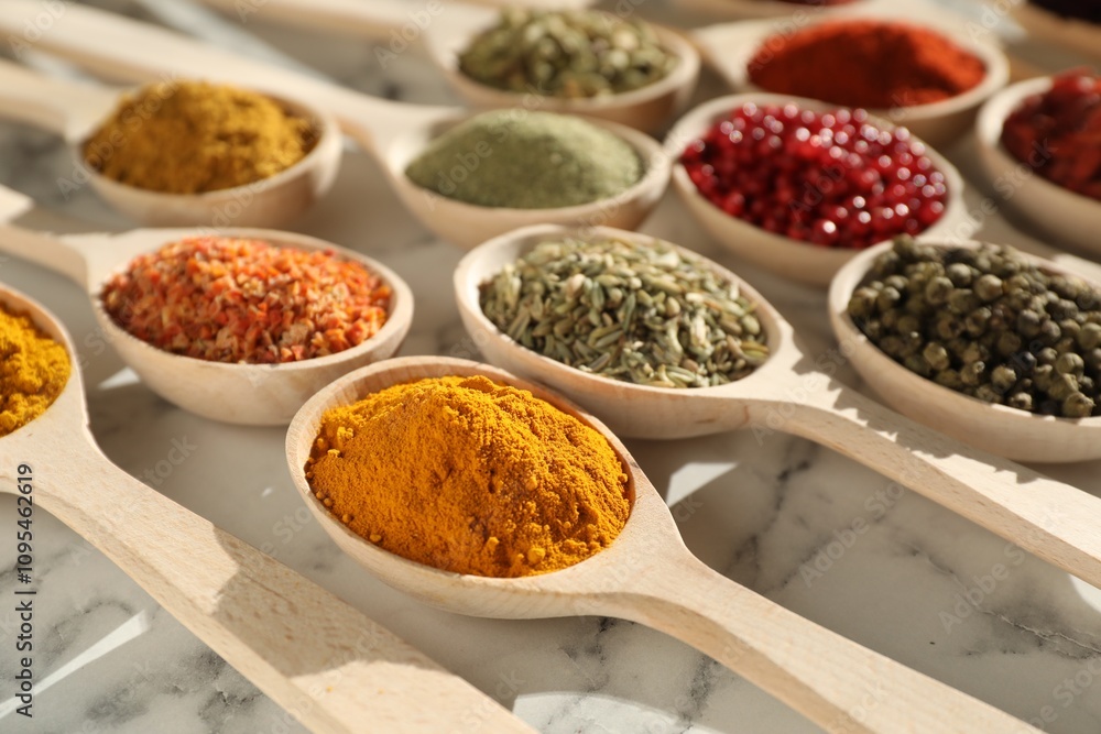 Different aromatic spices in spoons on white marble table, closeup Different aromatic spices in spoons on white marble table, closeup