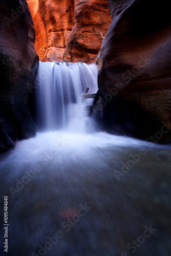 Fotografie Vertical, slow shutter speed of majestic waterfall in chasm