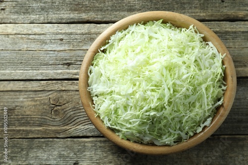 Fresh shredded cabbage on wooden table, top view. Space for text