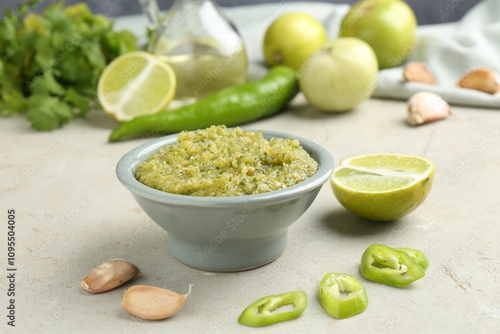 Delicious salsa sauce in bowl and products on light textured table, closeup Delicious salsa sauce in bowl and products on light textured table, closeup