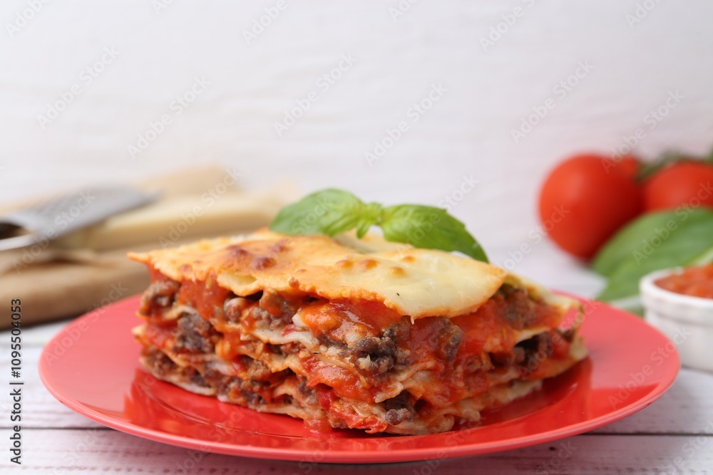 Piece of delicious cooked lasagna with basil on light wooden table, closeup Piece of delicious cooked lasagna with basil on light wooden table, closeup