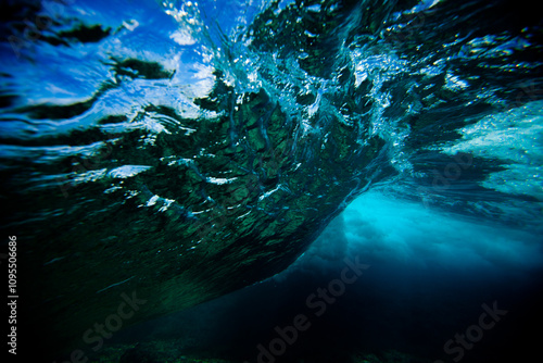 Beneath a rolling ocean wave, underwater