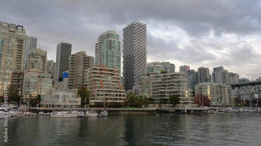 Vancouver Bridge on a cloudy day. Skyscrapers in the city, development by the water, yachts, pier. Vancouver skyscrapers. A small ship. A ship under the bridge. Vancouver Bridge on a cloudy day. Skyscrapers in the city, development by the water, yachts, pier. Vancouver skyscrapers. A small ship. A ship under the bridge.