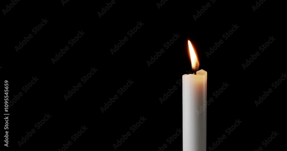 A single white candle burning. Isolated candle slow motion burning with dark background. White paraffin candle with yellow shades burns on a black background. Slow motion. A single white candle burning. Isolated candle slow motion burning with dark background. White paraffin candle with yellow shades burns on a black background. Slow motion.