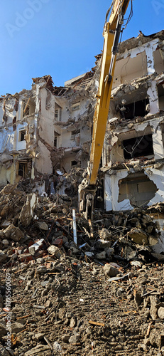 Demolition of building. Excavator breaks old house. long armed demolition machine seen demolishing a building.