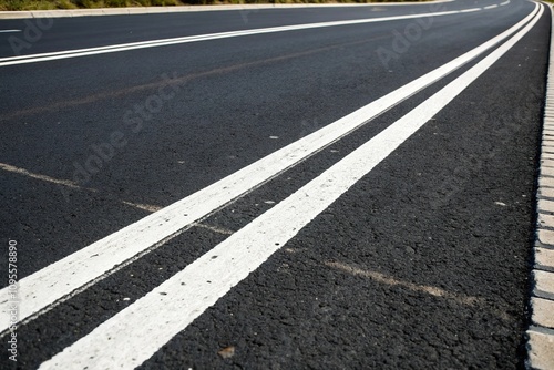 Close-up view of white dividing lines on a black asphalt road, white stripes, urban infrastructure, black asphalt, lane separator