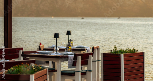 Canvastavla A cozy table at a waterfront cafe overlooking the bay, set for a romantic and tranquil dining experience at sunset