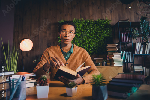 Young student studying with focus in cozy apartment surrounded by books and greenery