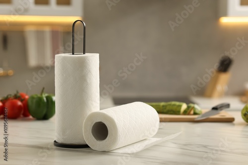 Rolls of paper towels and vegetables on white marble table in kitchen, space for text photo