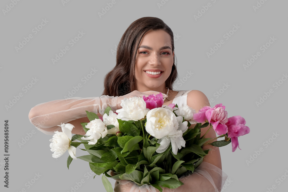 Beautiful young woman with bouquet of peony flowers on grey background Beautiful young woman with bouquet of peony flowers on grey background
