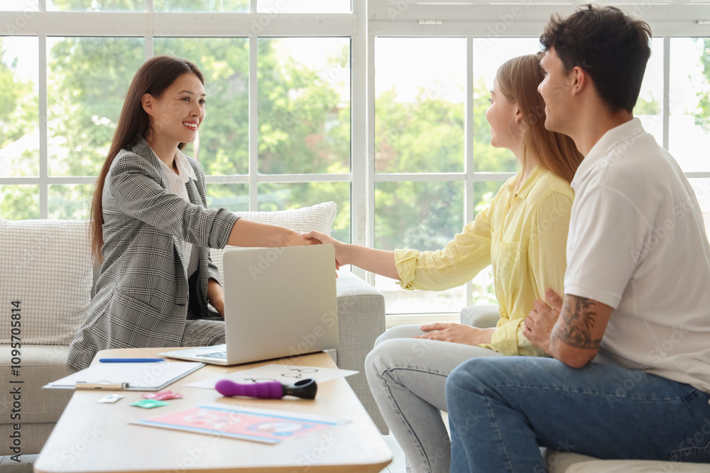Female Asian sexologist working with young couple in office Female Asian sexologist working with young couple in office