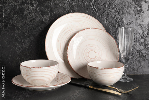 Set of beautiful tableware on black grunge background