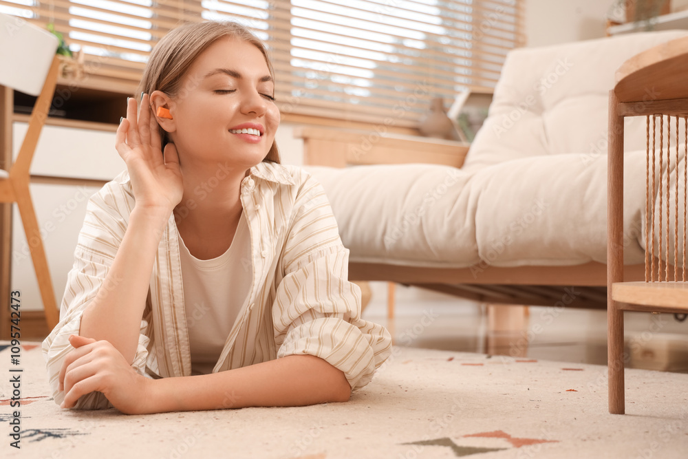 Young woman with earplugs lying on floor at home Young woman with earplugs lying on floor at home