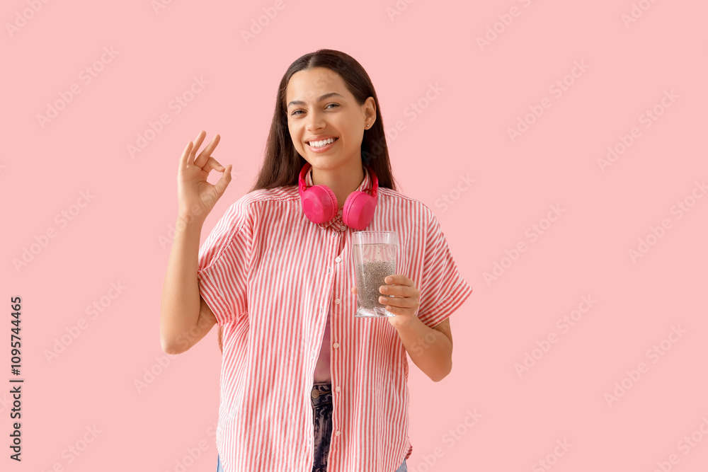 Young woman with chia seed water showing OK on pink background Young woman with chia seed water showing OK on pink background