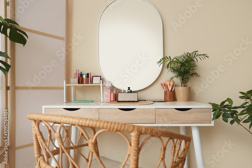 Makeup table with cosmetics and plant in dressing room photo