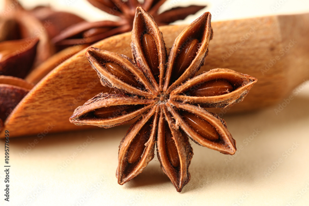 Wooden scoop with aromatic star anise on color background, closeup Wooden scoop with aromatic star anise on color background, closeup