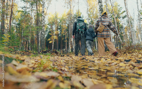 family walking in autumn forest photo