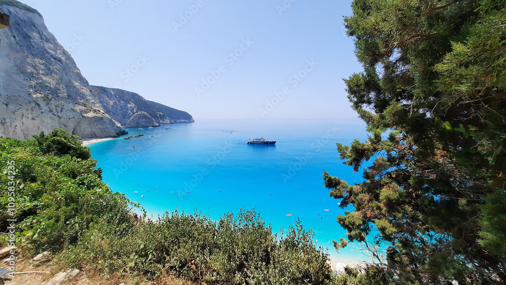 Fototapeta premium A boat is floating on the clear blue water with a blue sky