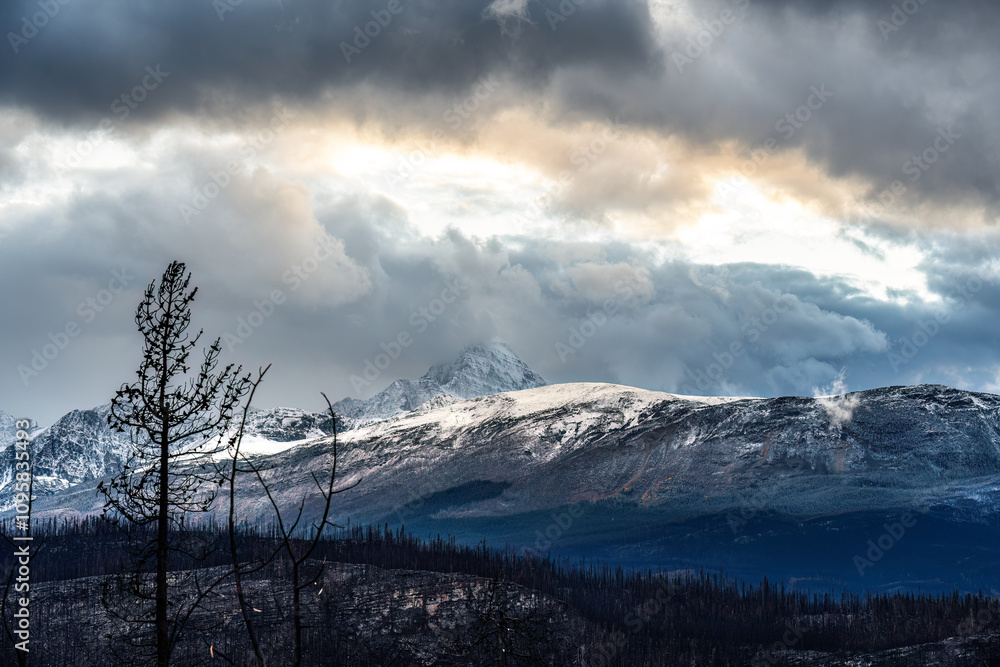 Obraz premium sunlight shed through cloudy sky to the peak of mountains