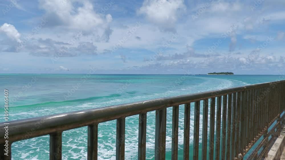 Railings at a walkway with ripples in the water created by a passing motor boat, Saipan Railings at a walkway with ripples in the water created by a passing motor boat, Saipan