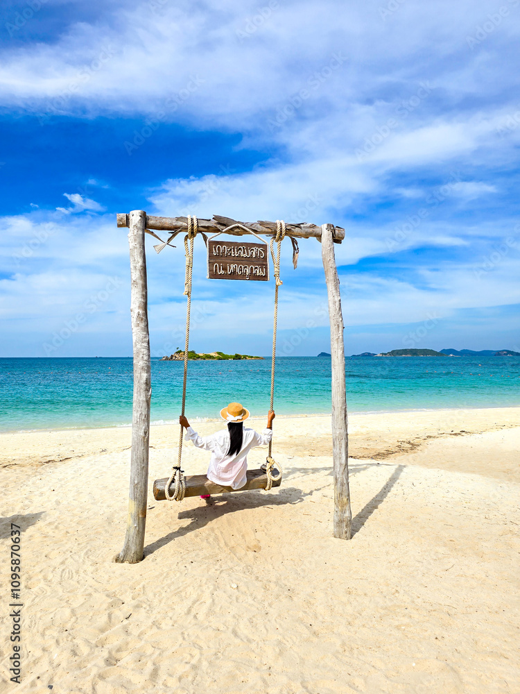 Relaxing on a beach swing at Samae San Island in Thailand under the sunny sky Relaxing on a beach swing at Samae San Island in Thailand under the sunny sky