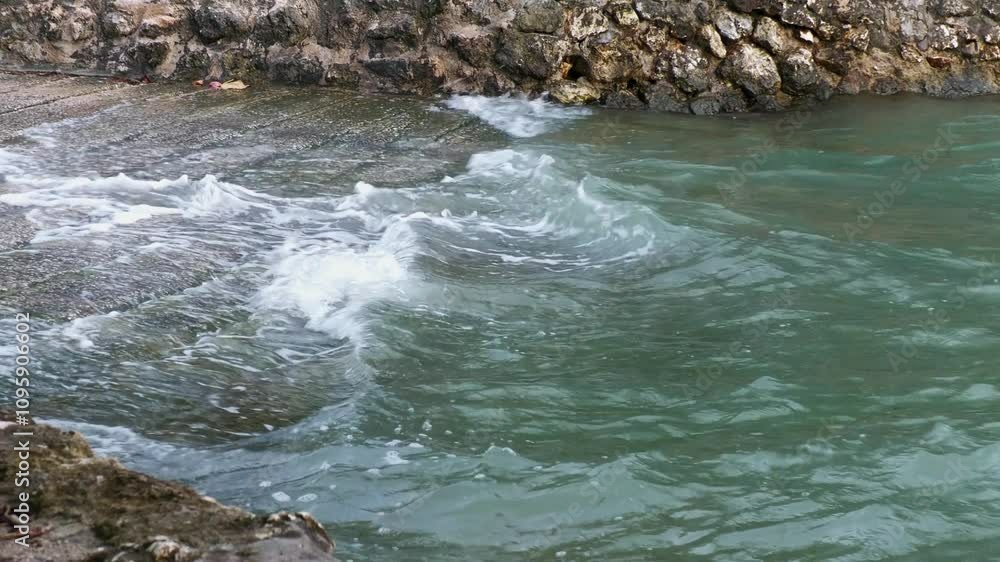 Waves rolling toward a concrete sloping boat dock, close up Waves rolling toward a concrete sloping boat dock, close up
