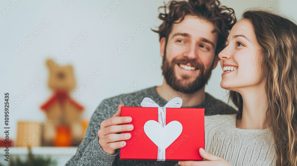 Happy Couple Celebrating With a Gift in a Cozy Home Setting During the Holiday Season Happy Couple Celebrating With a Gift in a Cozy Home Setting During the Holiday Season