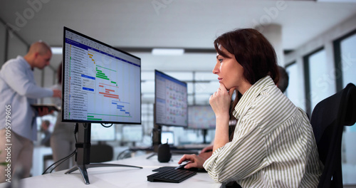 Businesspeople Analyzing Gantt Chart And Calendar On Computer photo
