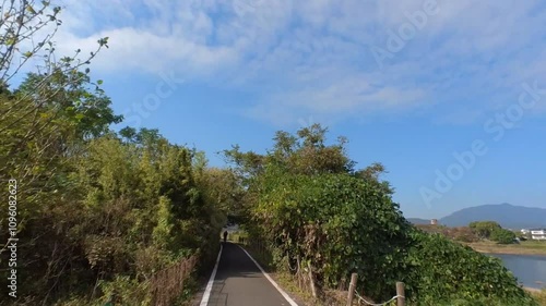 Wallpaper Mural FPV view from an action camera of cycling along Katsura River near Arashiyama under a blue sky on the Kyoto-Nara-Wakayama Cycling Road. A scenic ride through Japanese nature. Torontodigital.ca
