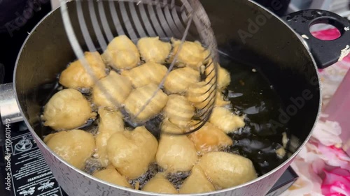 Pettole or pittule. Very soft leavened dough balls fried in boiling oil, typical of the Christmas period in southern Italy and of the day of Saint Cecilia - 4K photo